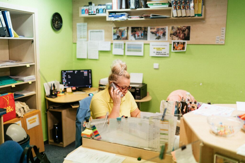 women in yellow shirt answering the phone in a nursing home